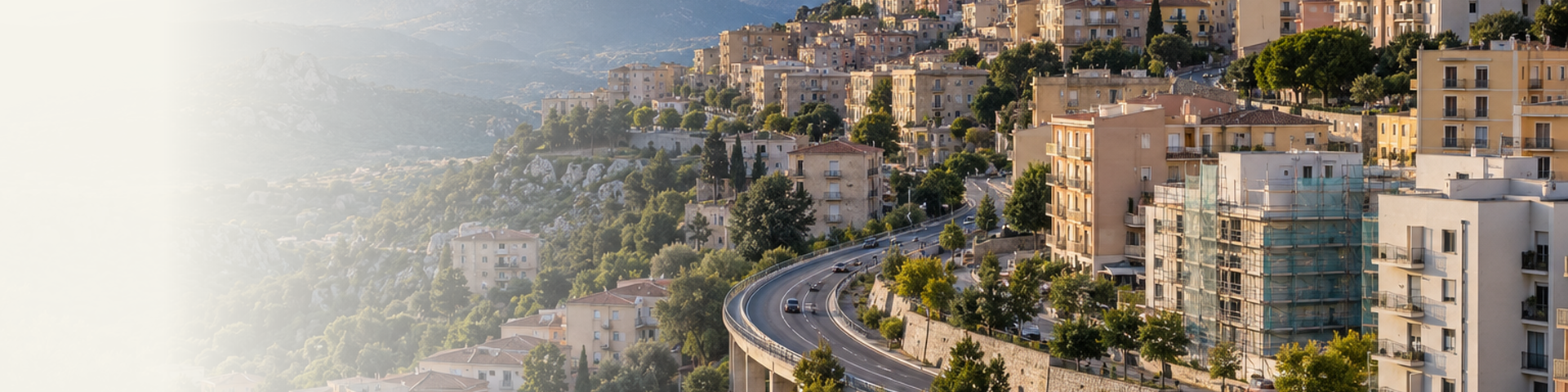 Veduta urbana di Nuoro con quartieri residenziali e collegamenti stradali nel paesaggio collinare.